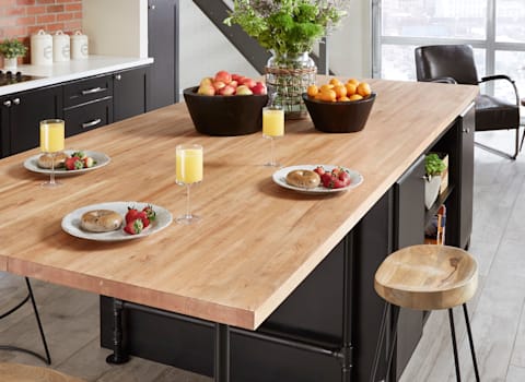 Counter set with bagels, fruit and orange juice. Kitchens with butcher block countertops have farmhouse style and craftsmanship that blends even with modern decor