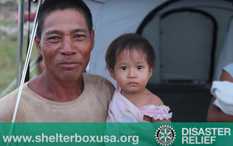 Shelterbox image of man and child. LL Flooring supports Shelterbox in the Philipines.