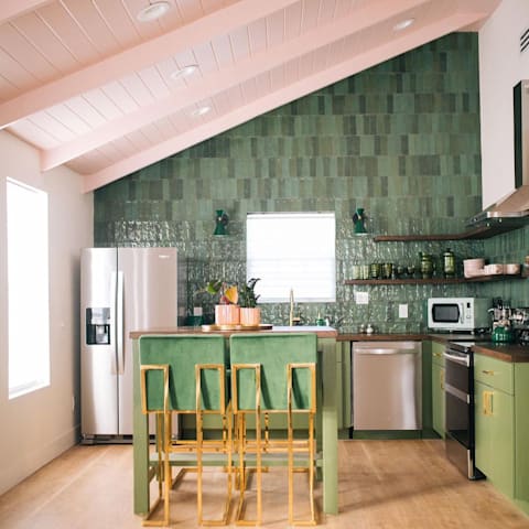 Kitchen designed by Myranda Randle uses a muted pink on ceilings mixed with more dramatic greens for a perfect mix of colors and textures, featuring Duravana Bay Bridge Oak waterproof hybrid resilient flooring.