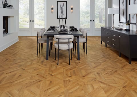 8mm Chapel Oak Waterproof Laminate Flooring in dining room with black dining table and credenza with cream armless dining chairs and black and white artwork