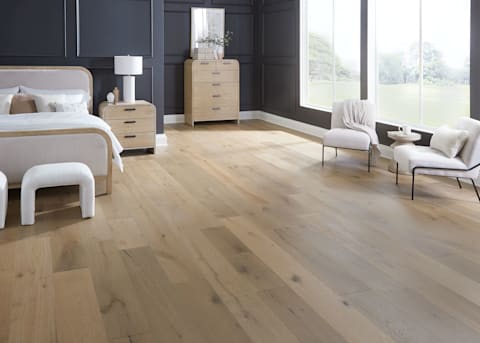 5/8 in x 9.5 in Tarpon Bay White Oak Distressed Engineered Hardwood Flooring in bedroom with black walls plus white upholstered armless chairs and blonde wood furnishings