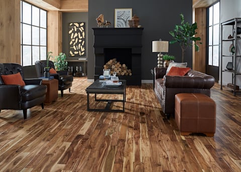 3/4 in. x 3.6 in Tobacco Road Acacia Solid Hardwood Flooring 3/4 in. x 3.6 in Tobacco Road Acacia Solid Hardwood Flooring in living room with dark brown leather furniture and black fireplace
