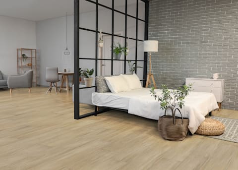 7mm+Pad x 7.48 in Latte Water-resistant Distressed Engineered Bamboo Flooring 7mm+Pad x 7.48 in Latte Water-resistant Distressed Engineered Bamboo Flooring in studio with white washed brick accent wall and bed with simple bedding