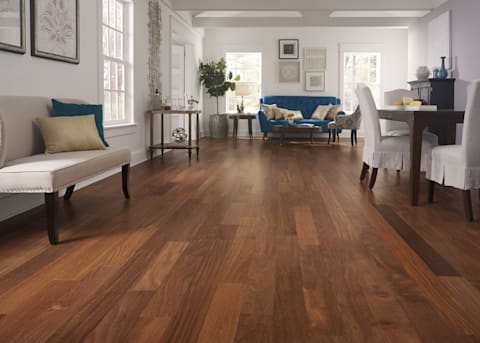 This living room has a stylish yet classic look, with blue sofa, interesting wall decor, and installation of warm Matte Brazilian Chestnut Solid Hardwood Flooring, a select-grade solid wood floor.