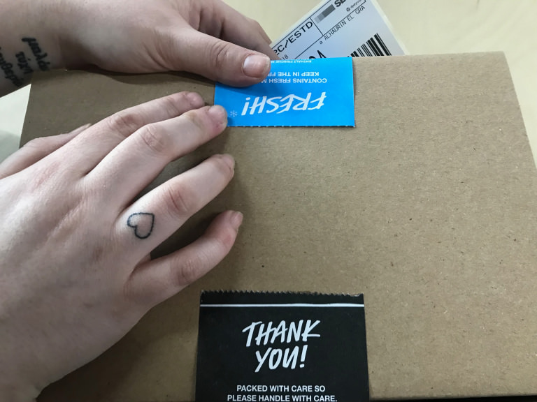 María envuelve con amor un paquete de la tienda online de Lush María, del equipo de la tienda online de Lush, cierra un paquete