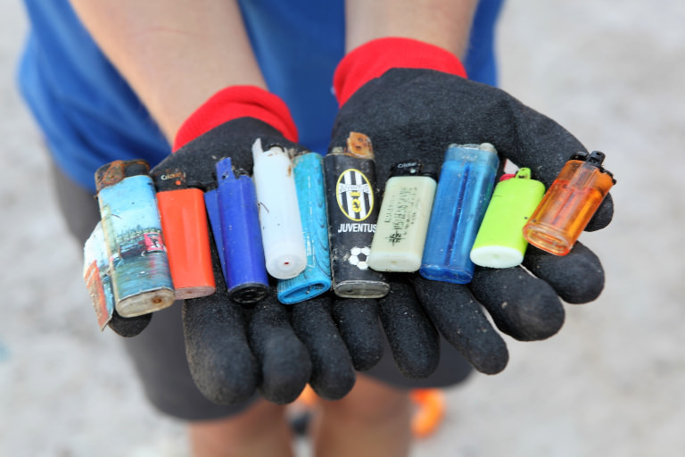 Una colección de mecheros oxidados encontrados en la playa Mecheros encontrados en la arena de la playa