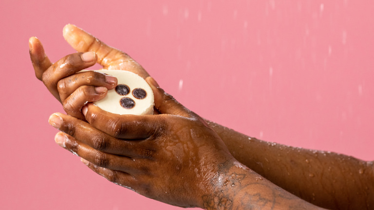 Aceite de ducha sólido zero waste Coco Loco Alguien aplicando el aceite de ducha sólido zero waste coco loco con aceite y harina de coco para limpiar y suavizar la piel
