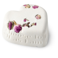 white heart shaped bath bomb with dried roses embedded into it 