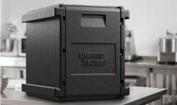 Thermobox noir de Thermohauser posé sur une table en acier inoxydable dans une cuisine