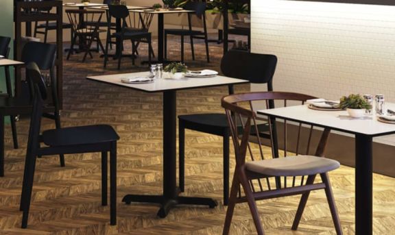 Eingerichtetes Restaurant mit schwarzen Stühlen und Tischsäulen Regulo von FLAT