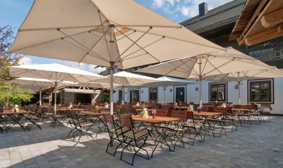 Sonnenschirme von doppler in beige aufgespannt auf einem Außenbereich in einem Innenhof platziert