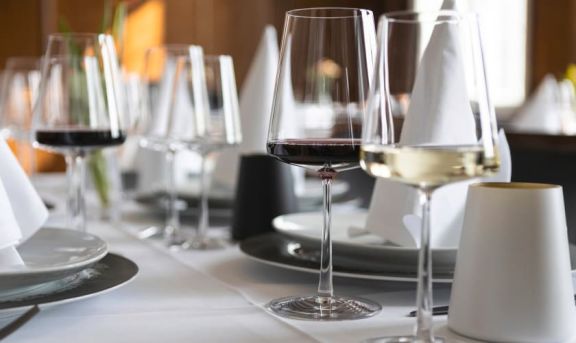 Glasserie Power von Stölzle mit Wein befüllt auf einem weißen Tisch platziert