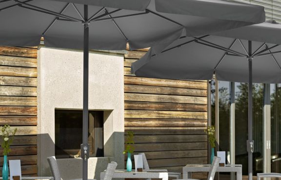Cielo-parasol fra VEGA i grå på en solrig terrasse