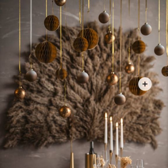 An der Decke befestigte Weihnachtskugeln in gold und braun.