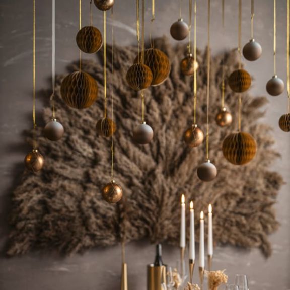 An der Decke befestigte Weihnachtskugeln in gold und braun.