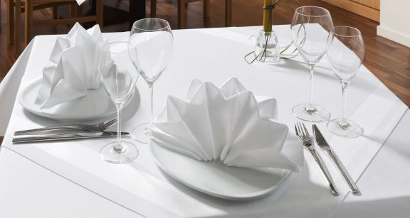 Mesa puesta con mantel y servilletas dobladas
