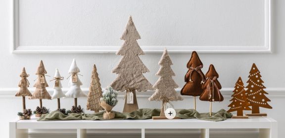 Sideboard dekoriert mit vielen verschiedenen kleinen Tannenbaum Figuren.