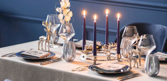 Festlich in blau und silber geschmückter Esstisch. Silberner Adventskranz mir Hirschen.