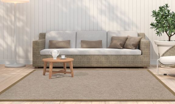 In- & Outdoor Teppich Taffino Como Teppich von Grundstoff in braun auf einer Terrasse platziert mit einem Sofa im Hintergrund