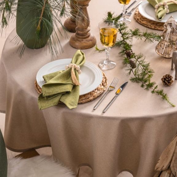 Festlich in grün und braun gedeckter Tisch mit einer beigefarbenen Tischdecke.