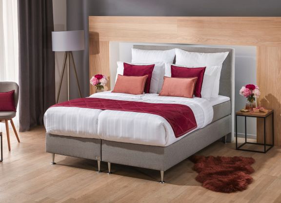 eingerichtetes Schlafzimmer mit einem Bett in der Mitte