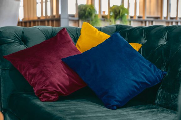 Dekokissenbezüge Samara in gelb, rot und blau auf Sofa Chersterfield in grün