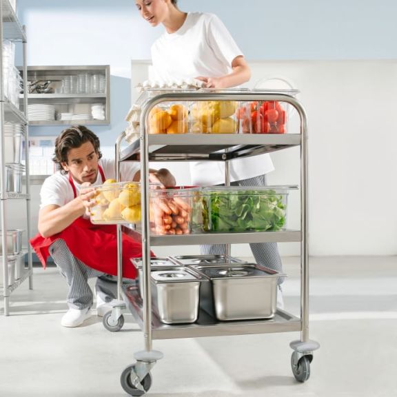 Küchenhilfen räumen einen Servierwagen ein