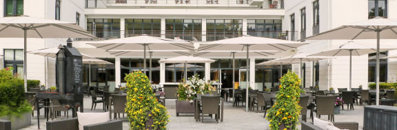 graue Sonnenschirme von der Marke May auf einer Außenfläche eines Restaurants platziert