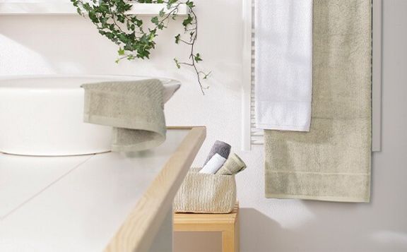 Ausschnitt eines Badezimmer mit Fokus auf Waschbecken und Handtüchern