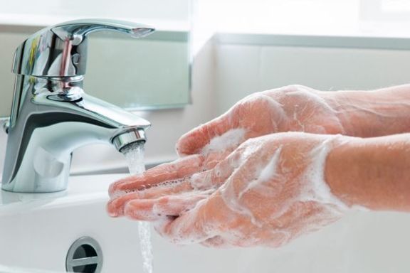 Eingeseifte Hände werden unter fließendem Wasser gewaschen