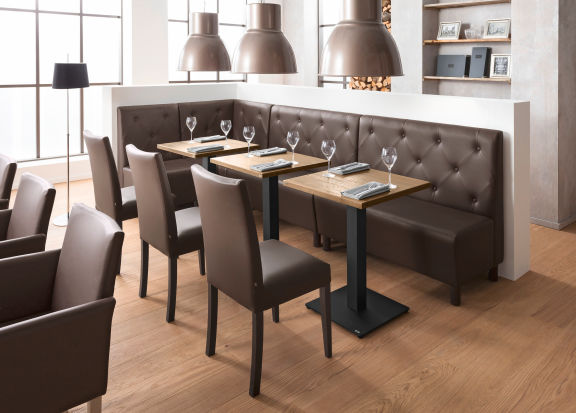 Blick in eine gemütliche Ecke in einer Bar mit braunen Gastronomie-Möbeln