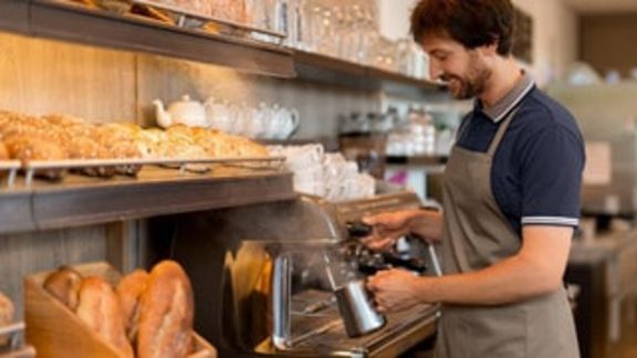 Blick auf die Auslage einer Bäckerei mit Verkäufer