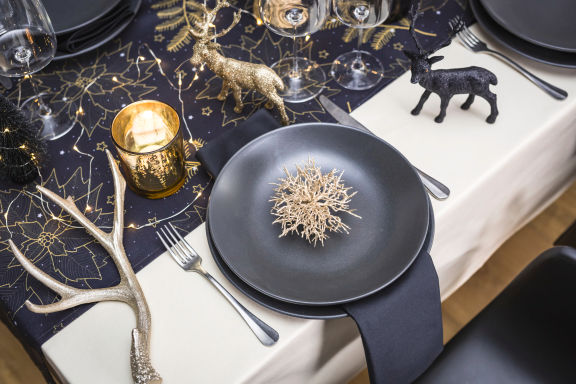 Apparecchiare la tavola di Natale con piatti neri e oro