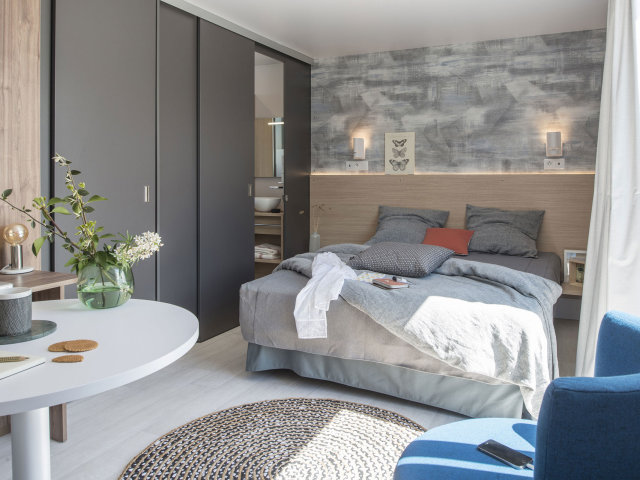 Le lit parental d’un mobil home au camping La Capricieuse en Normandie.