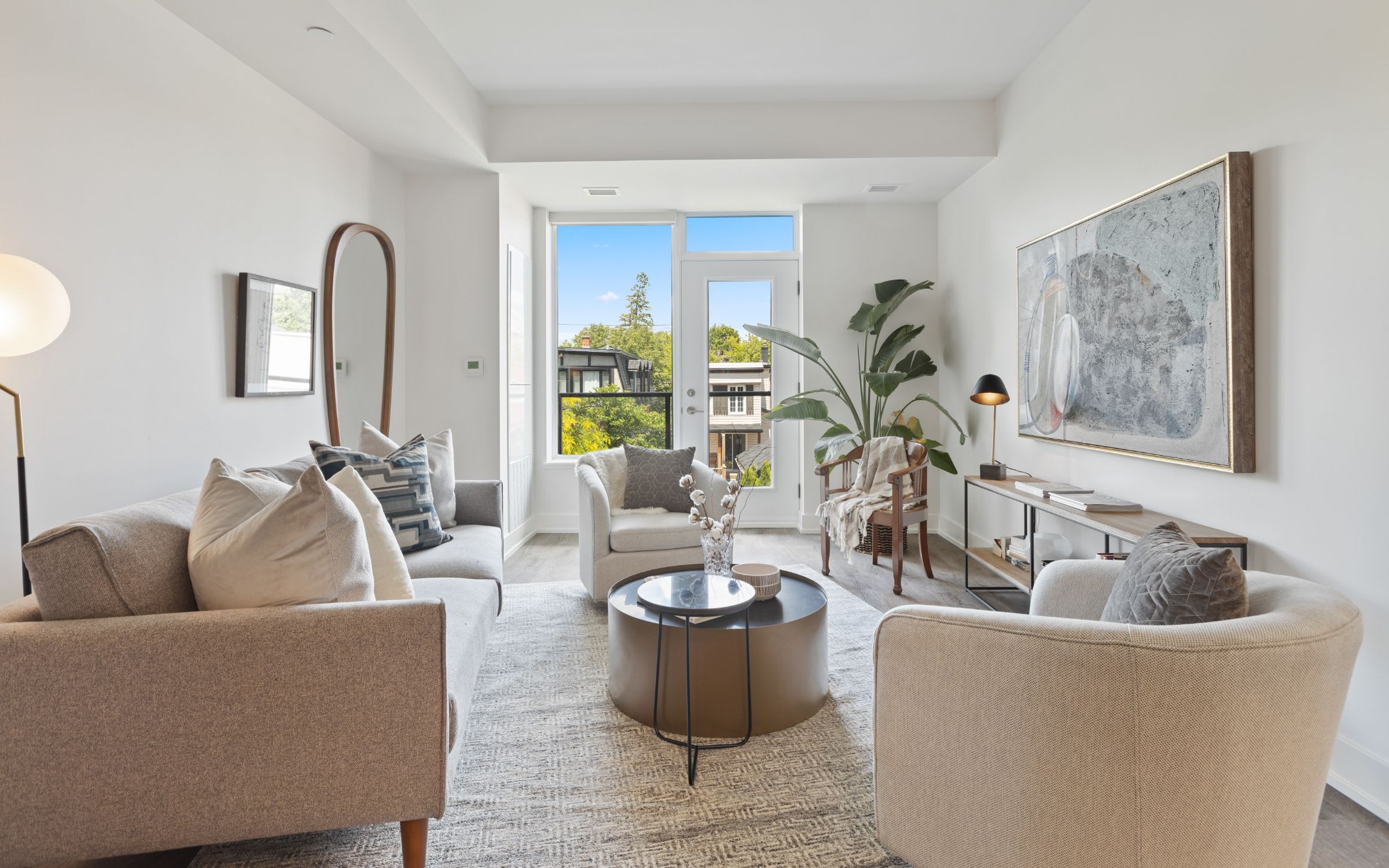 A modern living room with white walls and a large window overlooking a city view