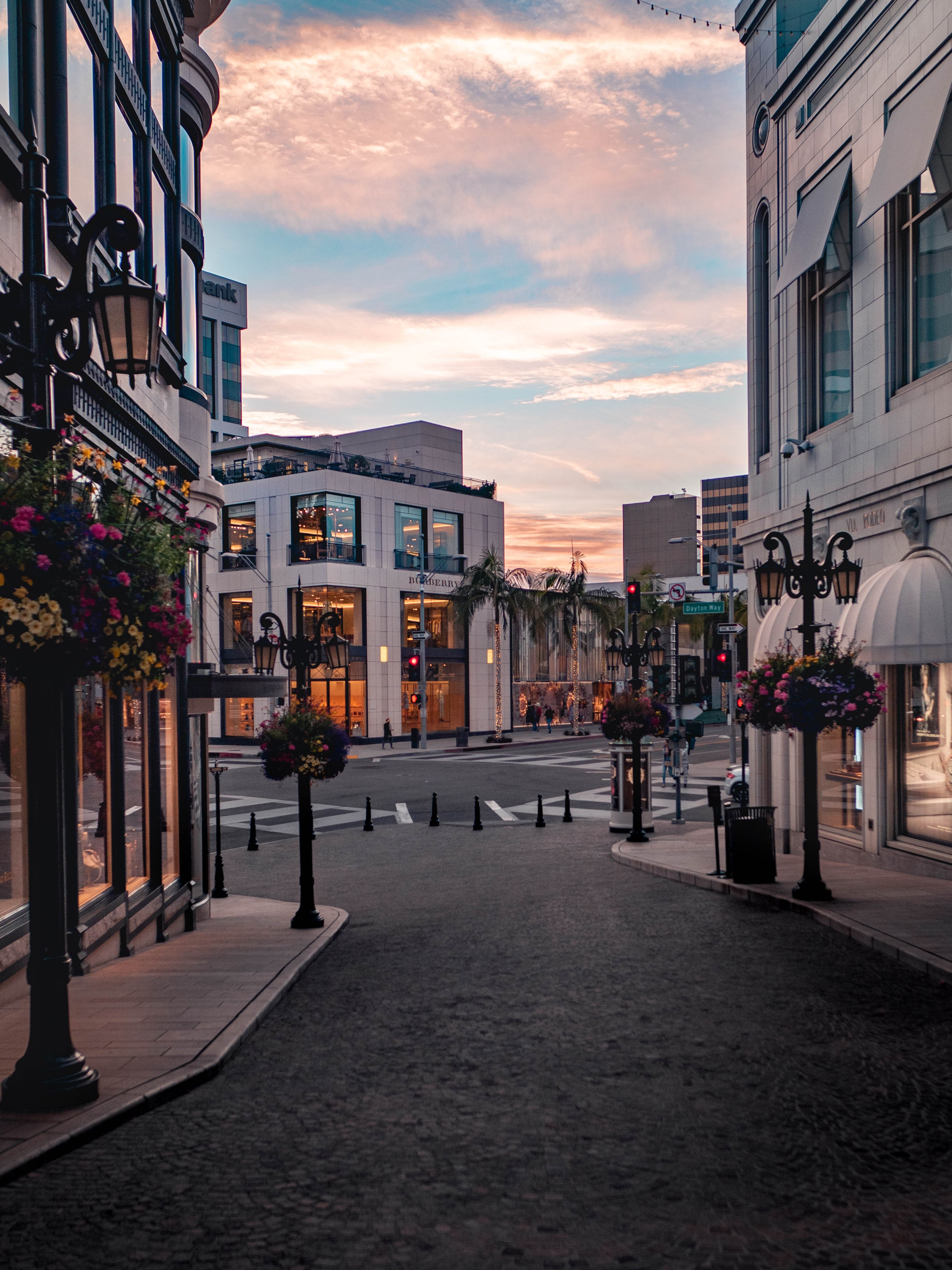 A cobblestone street lined with tall buildings at sunset.