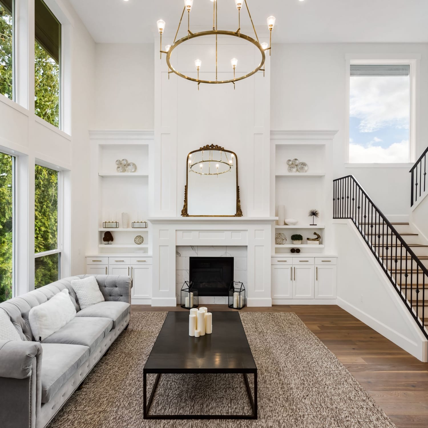 A spacious living room with a high ceiling and large windows