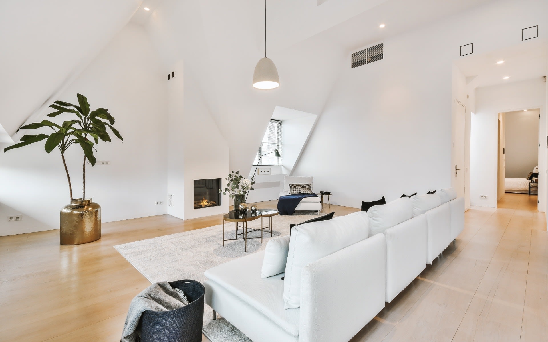 A cozy living room with a white couch facing a fireplace