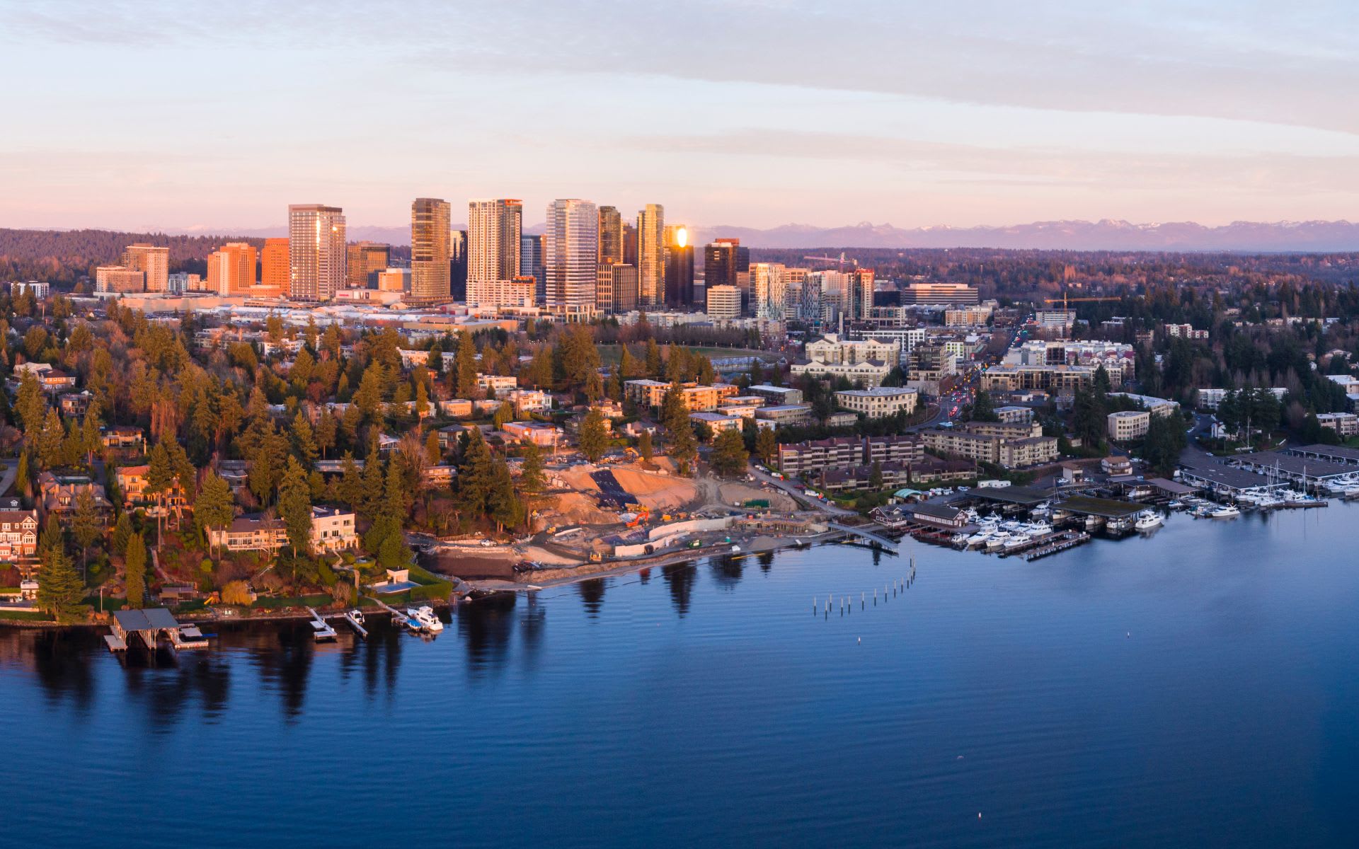 An aerial view of a city skyline with a calm lake in the foreground.