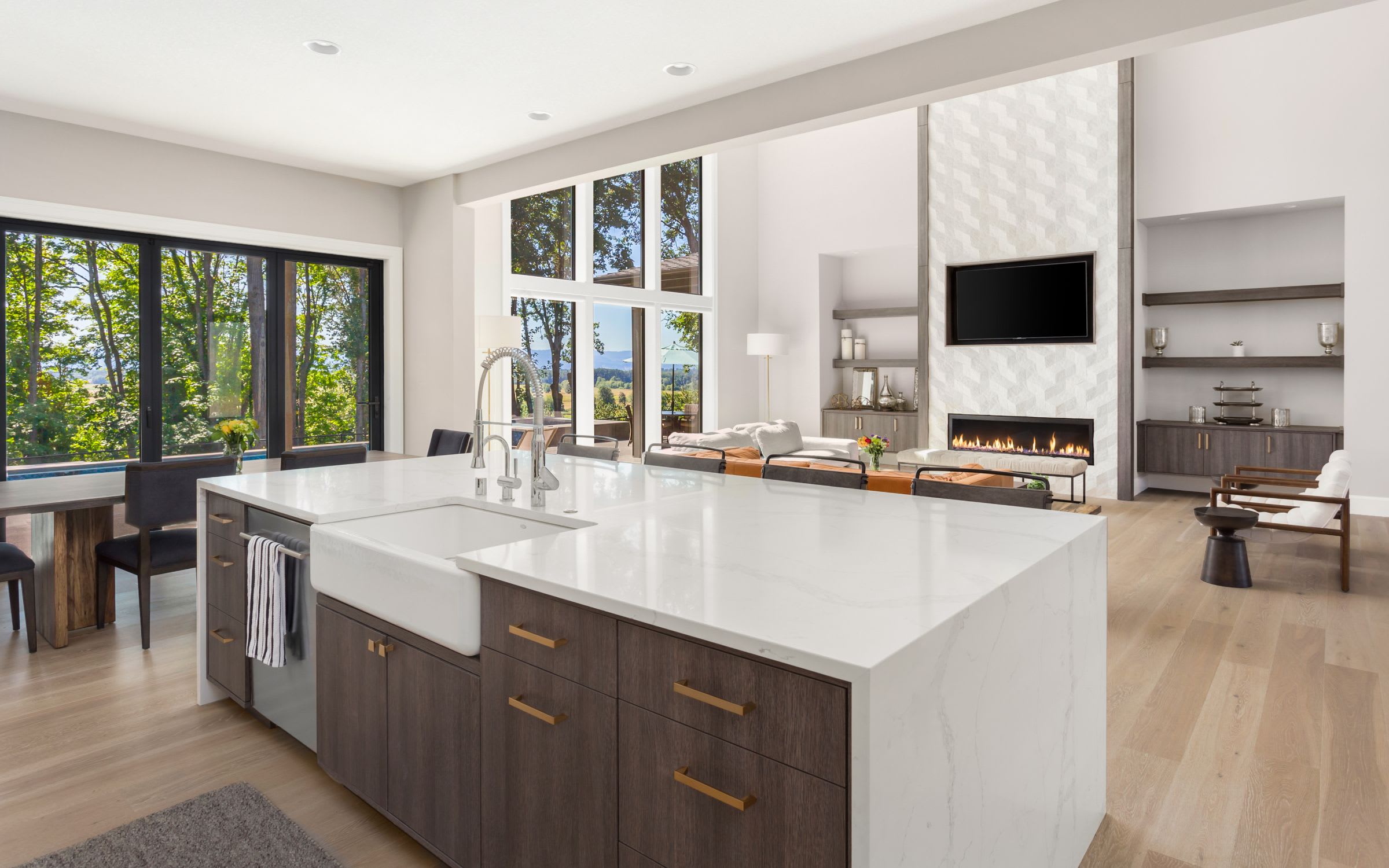 A modern kitchen and living room with large windows