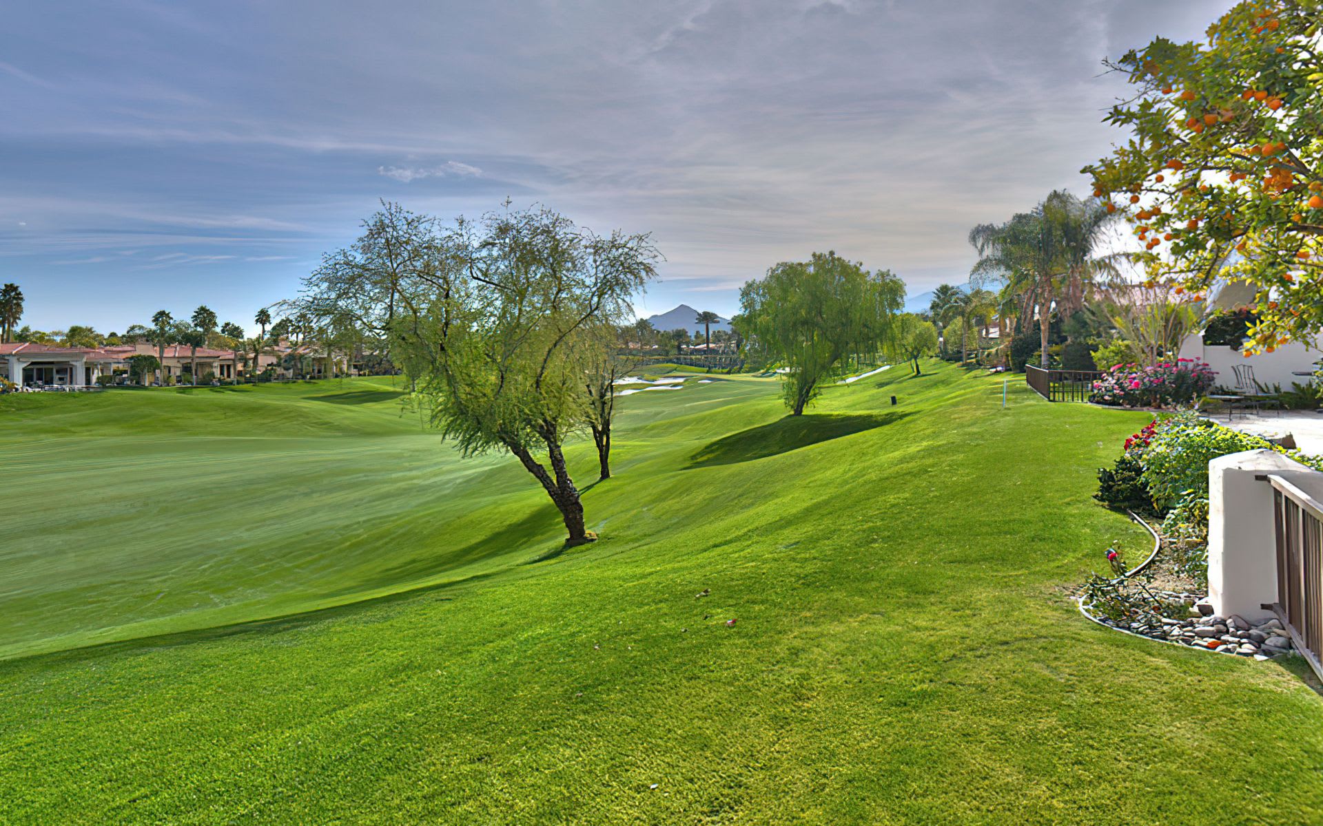 A panoramic view of a lush green golf course with rolling hills