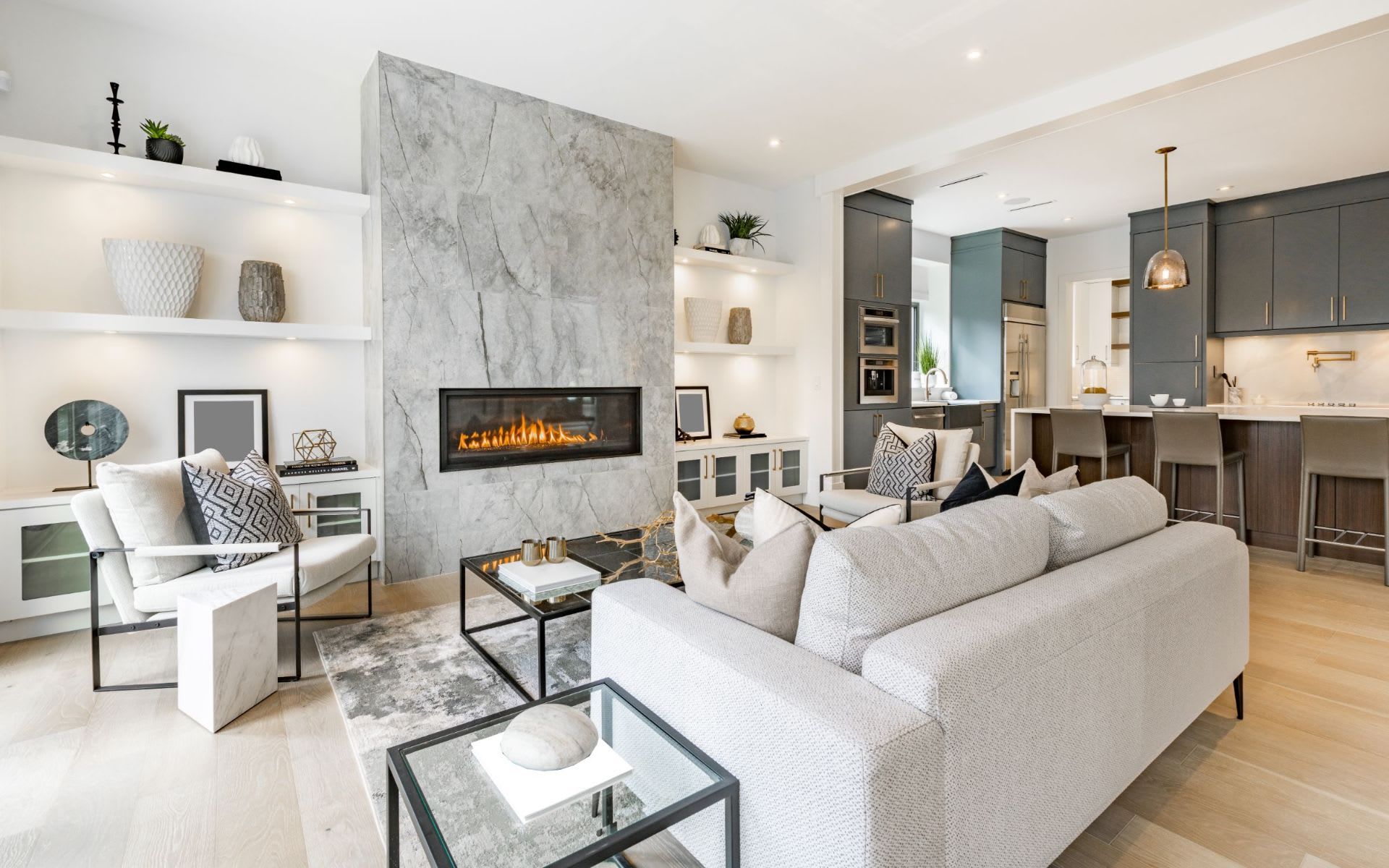A modern, open-concept living room with a sleek marble fireplace