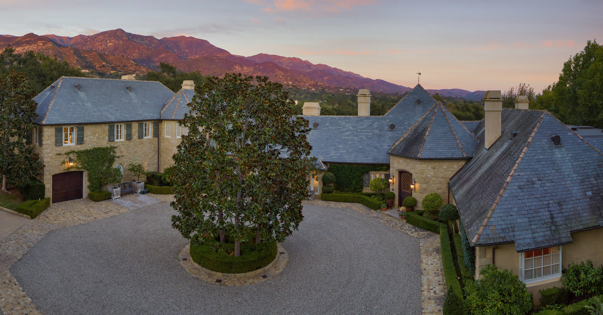 A beautiful aerial view of a mansion with mountains in the background