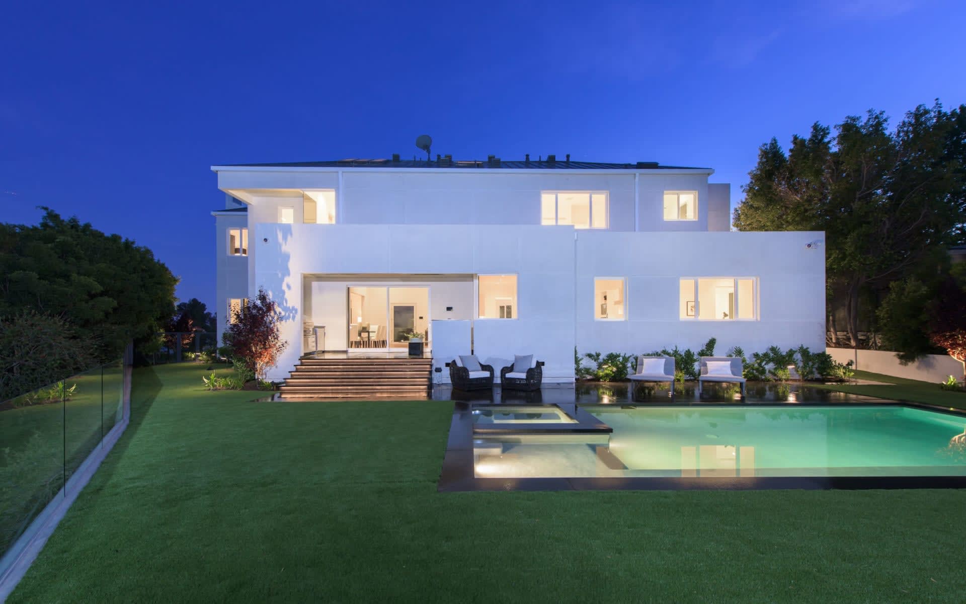 A large white house with a swimming pool in the backyard