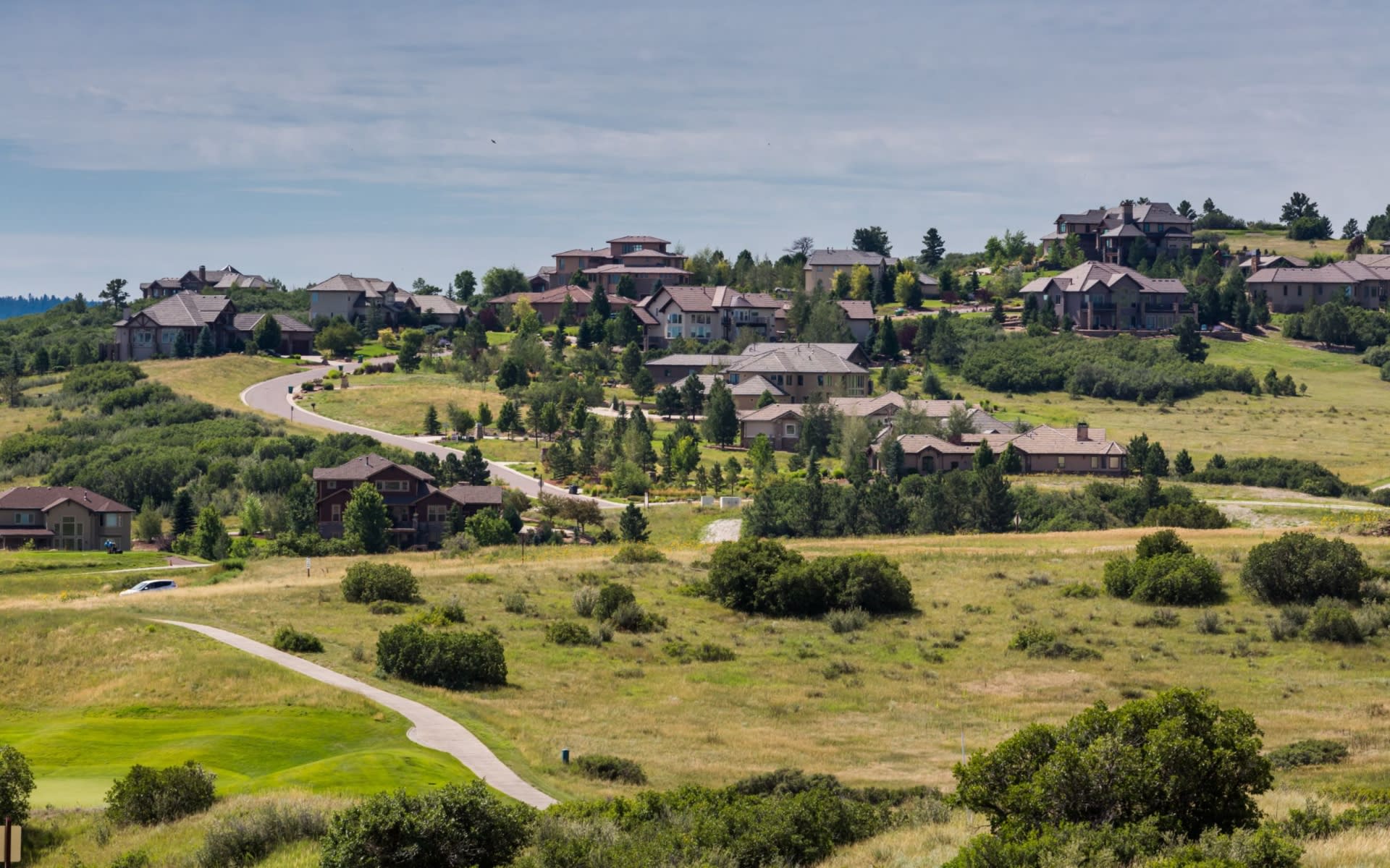 Scenic hillside landscape with luxury homes and open green space