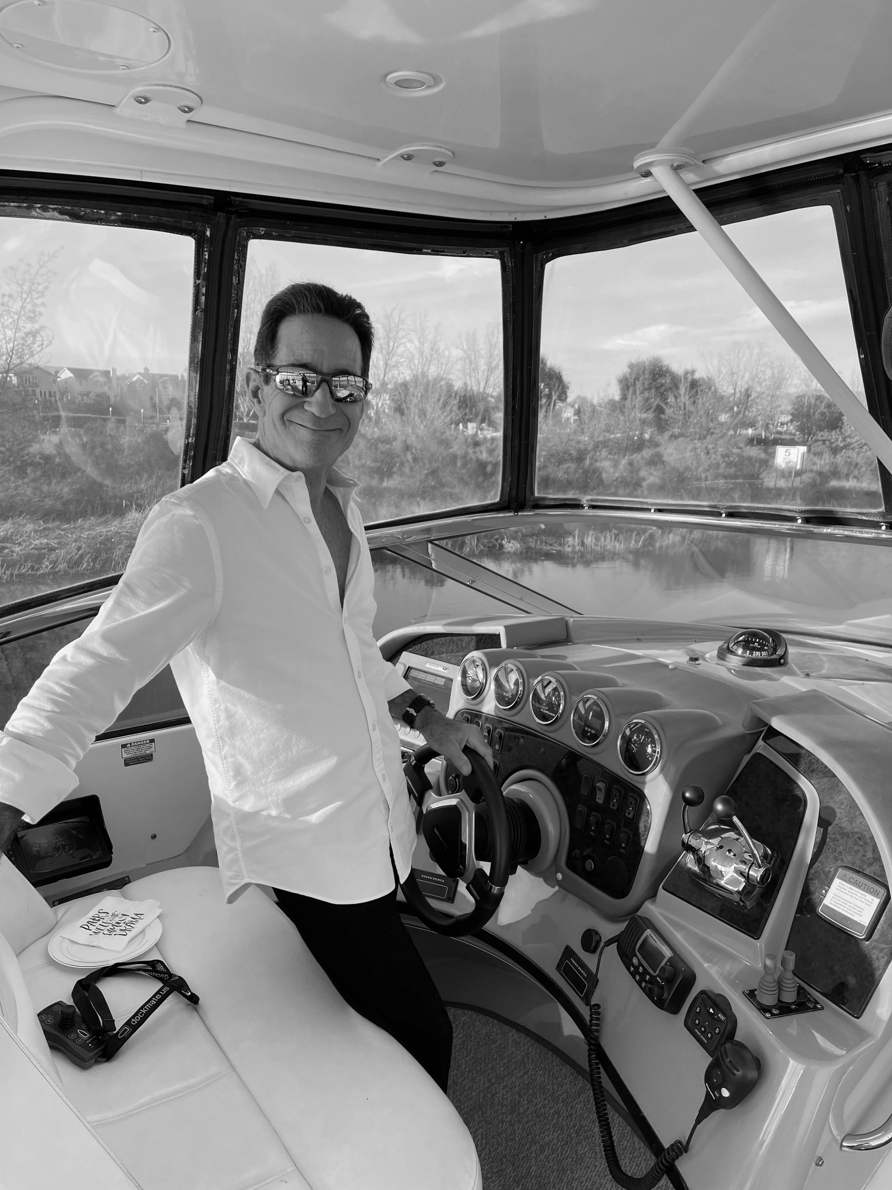 black and white image of Avi Strugo inside a yatch holding the steering wheel