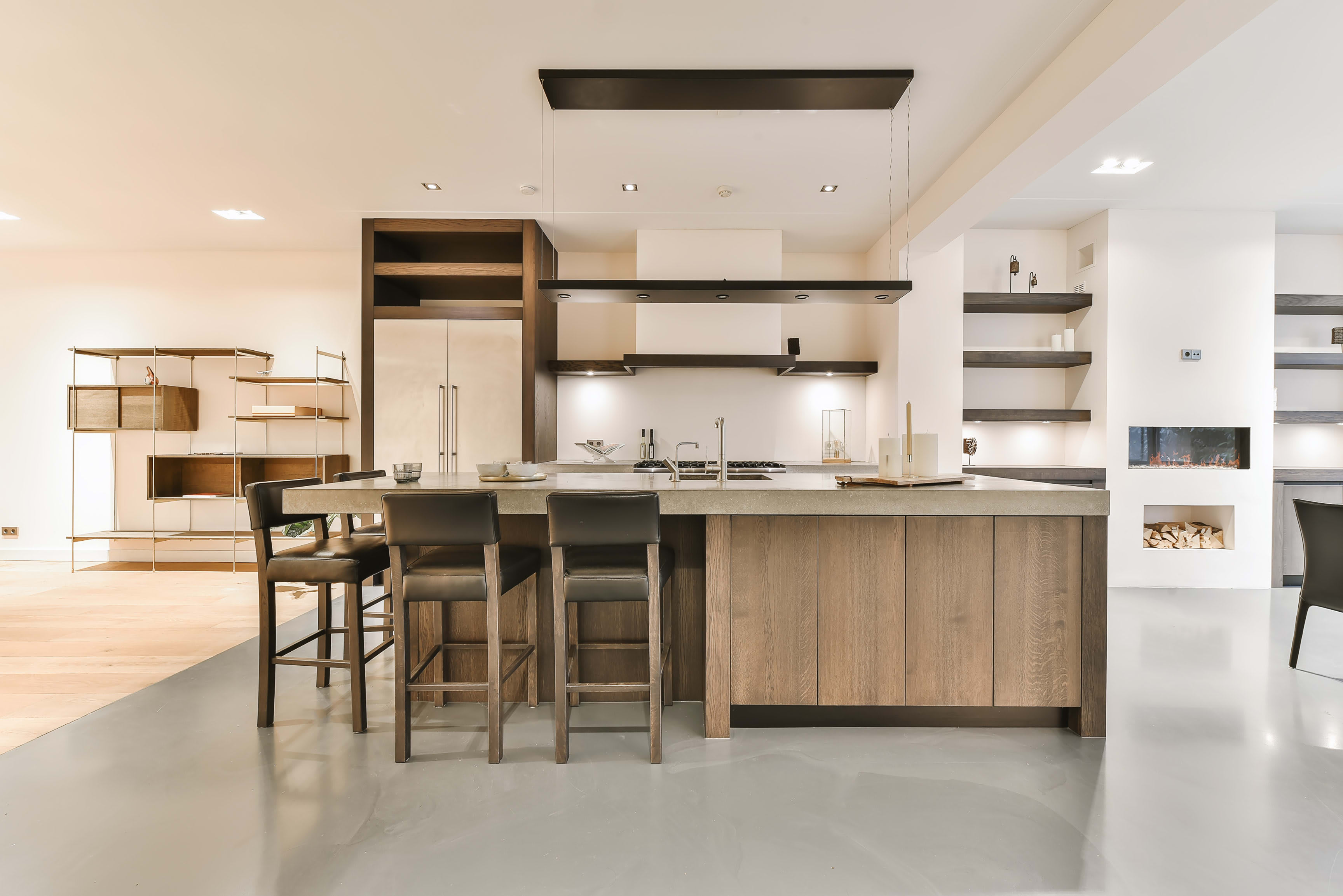 A modern kitchen with a large island in the middle and bar stools