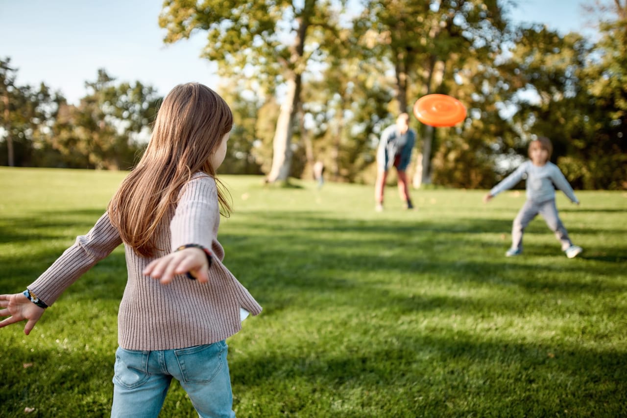 two kids playing Frisbee in the park