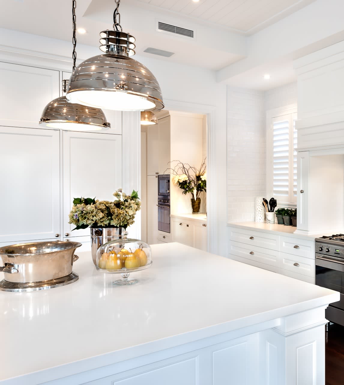 A modern kitchen with a large white center island and a breakfast bar.