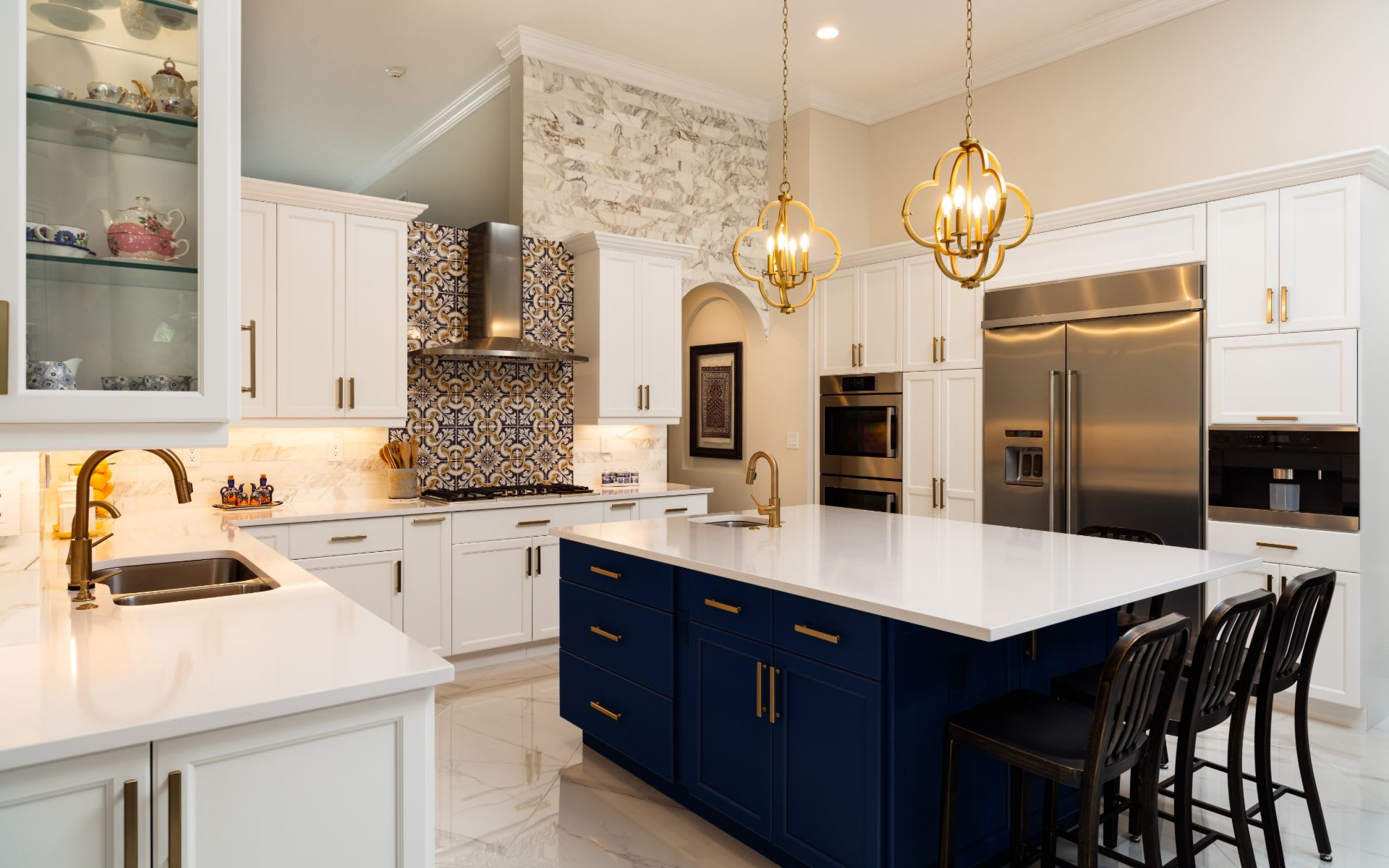 A kitchen with white cabinets, a blue island, and stainless steel appliances